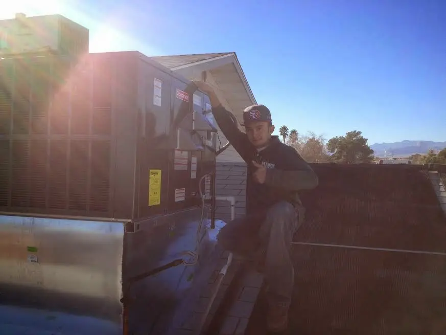HVAC technician performing Heat Pump Repair on a rooftop unit in Winona Lake
